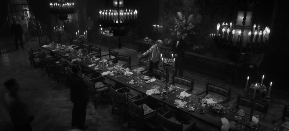 <p><strong>Production design by Donald Graham Burt; set decoration by Jan Pascale.</strong></p><p>David Fincher's <em>Mank </em>is based on screenwriter Herman Mankiewicz’s (portrayed by Gary Oldman) time writing the script for the iconic film <em>Citizen Kane</em>. Coming in with 10 nominations, <em>Mank</em> is one of the most buzzed-about films of the year. Production designer Donald Graham Burt and Fincher have been working together since <em>Zodiac</em> (2007) and are clearly a winning combination. They’ve collaborated on Academy Award–nominated films (and winners) such as <em>The Curious Case of Benjamin Button</em> (2008), <em>The Social Network</em> (2010), and <em>The Girl with the Dragon Tattoo</em> (2011).</p><p>For <em>Mank</em>, Graham Burt had to create authentic sets to accurately convey the Golden Age of Hollywood <em>and</em> think about how the sets photographed in black and white. ‘‘There was certainly a learning curve in approaching the black-and-white aspect of the film,’’ Graham Burt told <em>ELLE Decor </em>in an e-mail. ‘‘We couldn’t scenic the interiors in tones of orange and green merely because it photographed well, as it would be too jarring and distracting to the actors and take away from the reality we were attempting to portray. We developed a language of colors that, combined with glazes, functioned to keep the sets feeling real while also lending themselves to the richness of the black and white.’’</p><p>If you asked the designer what the most challenging part was, it would be recreating the Hearst Castle, formerly called the San Simeon estate, where the lavish parties were set. Since filming was not allowed on the estate, Graham Burt was left with two options: scout similar-looking locations or recreate the famous structure. He went with the latter and managed to build it on a soundstage in eight weeks. The castle emulated many different architectural styles, among them, Spanish Colonial, Classical, and Gothic. But the most illuminating insights for a dining scene came from <em>Hearst Castle Fare</em>, a vintage cookbook. “It had details about gatherings, table arrangements, place settings, furnishings, drink menus, and food menus,” he shares in a statement. </p><p>For <em>Mank’</em>s other location, North Verde Ranch (now called Kemper Campbell Ranch), where Mankiewicz was sent to write <em>Citizen Kane,</em> the team was thankfully granted an original for exterior shots, but had to devise the interiors themselves. They wanted to capture the vibe of a ‘‘dusty, desert bungalow where there was always the presence of a bright desert light outside.’’ Graham Burt continued. “It was important for Mankiewicz to feel sequestered and remote in a simpler environment.’’</p>