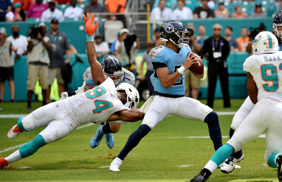 <p>Tennessee Titans quarterback Marcus Mariota (8) throws a pass as Miami Dolphins defensive end Robert Quinn (94) has his facemask pulled on by Tennessee Titans offensive tackle Taylor Lewan (77) during the first half at Hard Rock Stadium. Mandatory Credit: Steve Mitchell-USA TODAY Sports </p>