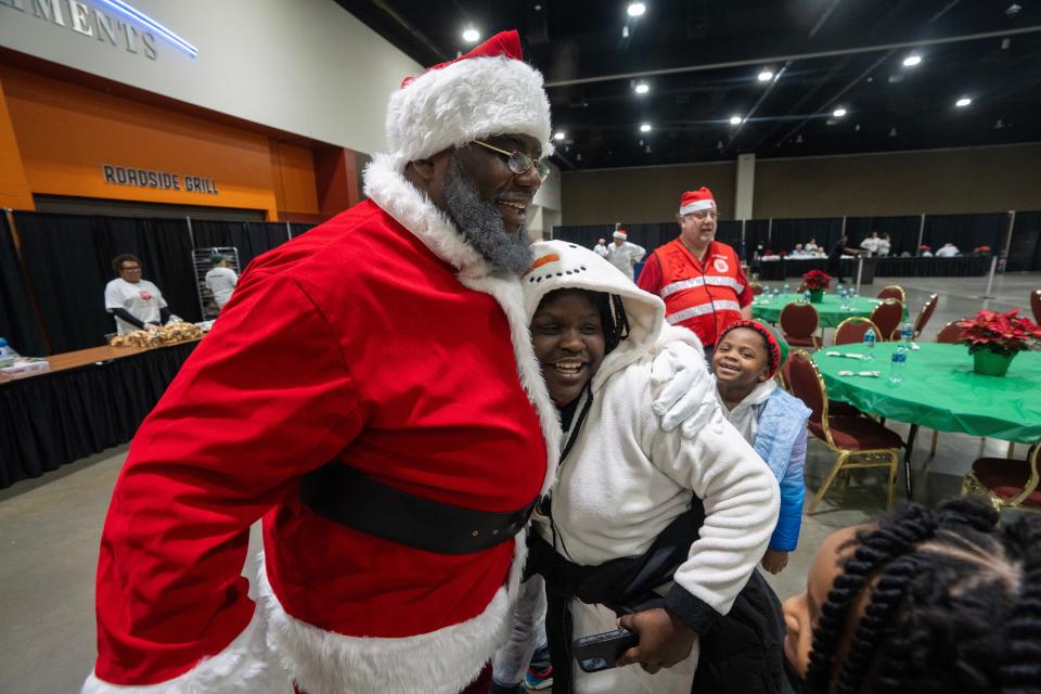 Making his annual appearance as Santa, Robert Boyd gets a hug from Brooklynn Washington, 12, at the annual Christmas Family Feast on Monday at the Wisconsin Center in Milwaukee. The Salvation Army expected to serve a Christmas dinner to about 4,000 people. Besides meals, guests could get complimentary haircuts, socks, bus passes and gifts. It is the largest feeding event hosted by The Salvation Army on Christmas Day in the country.