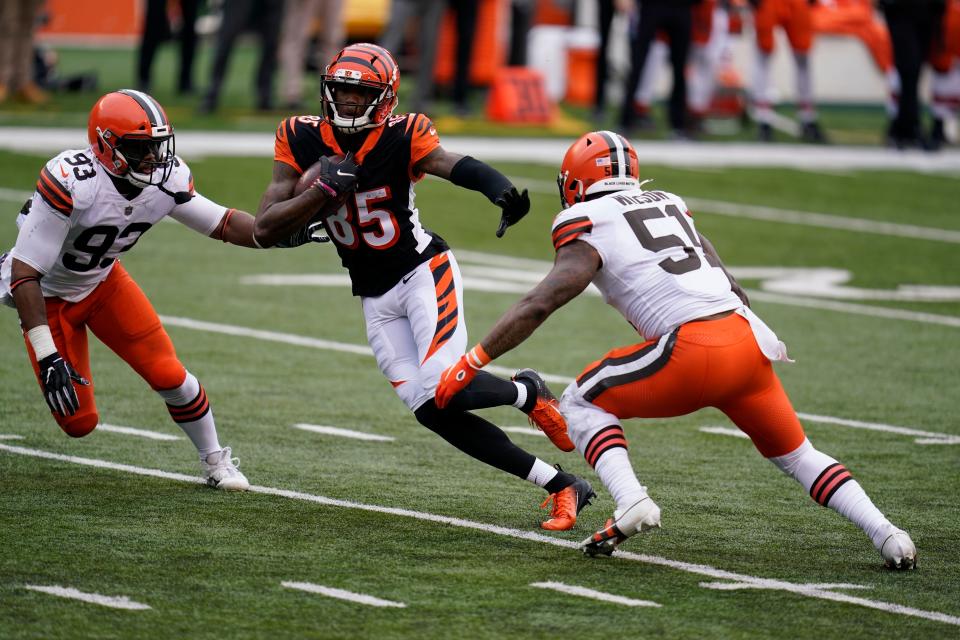 Cincinnati Bengals' Tee Higgins (85) makes a touchdown reception against Cleveland Browns' B.J. Goodson (93) and Mack Wilson (51) during the second half of an NFL football game, Sunday, Oct. 25, 2020, in Cincinnati. (AP Photo/Michael Conroy)