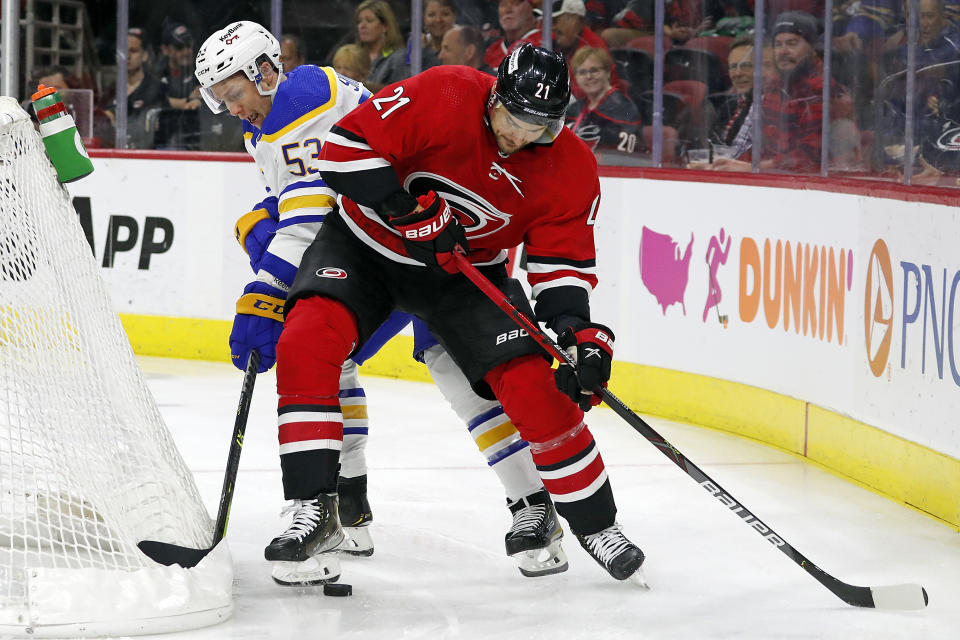 Carolina Hurricanes' Nino Niederreiter (21) protects the puck from Buffalo Sabres' Jeff Skinner (53) during the first period of an NHL hockey game in Raleigh, N.C., Thursday, April 7, 2022. (AP Photo/Karl B DeBlaker)