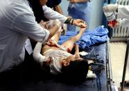 In this photo which AP obtained from the Syrian official news agency SANA, and has been authenticated based on its contents and other AP reporting, doctors treat a wounded Syrian boy at a hospital in Damascus, Syria, Tuesday, April 29, 2014. A series of mortar shells slammed into central Damascus on Tuesday, killing more than a dozen people and wounding scores, state media reported. The attacks in the Syrian capital came a day after President Bashar Assad announced his candidacy for the June 3 presidential election. (AP Photo/SANA)