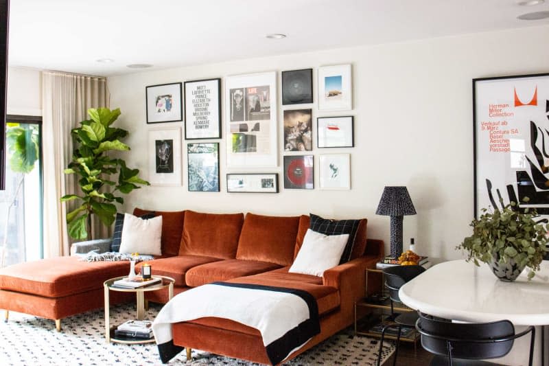 Rust colored sofa in art filled living room.