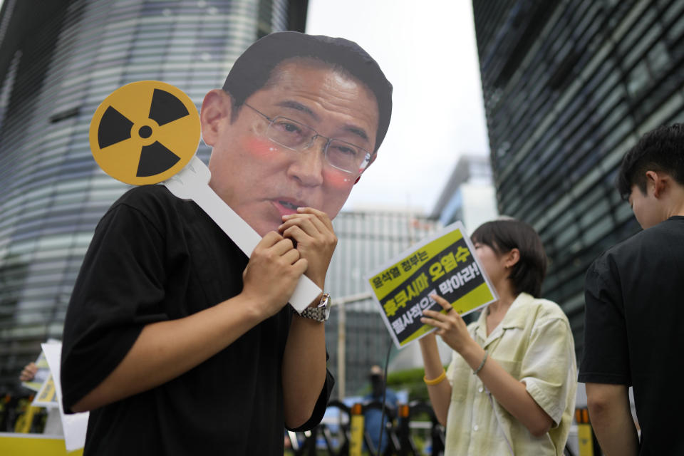 A student wearing mask of Japanese Prime Minister Fumio Kishida, walks during a rally to oppose Japanese government's plan to release treated radioactive water into the sea from the Fukushima nuclear power plant, in Seoul, South Korea, Wednesday, July 5, 2023. (AP Photo/Lee Jin-man)