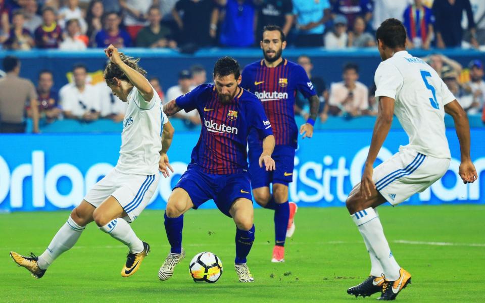 Lionel Messi #10 of Barcelona scores against the defense of Raphael Varane #5 and Luka Modric #10 of Real Madrid in the first half during their International Champions Cup 2017 match at Hard Rock Stadium on July 29, 2017 in Miami - Credit: Getty
