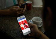 A cellphone user looks at a Facebook page at a shop in Latha street, Yangon, Myanmar August 8, 2018. REUTERS/Ann Wang