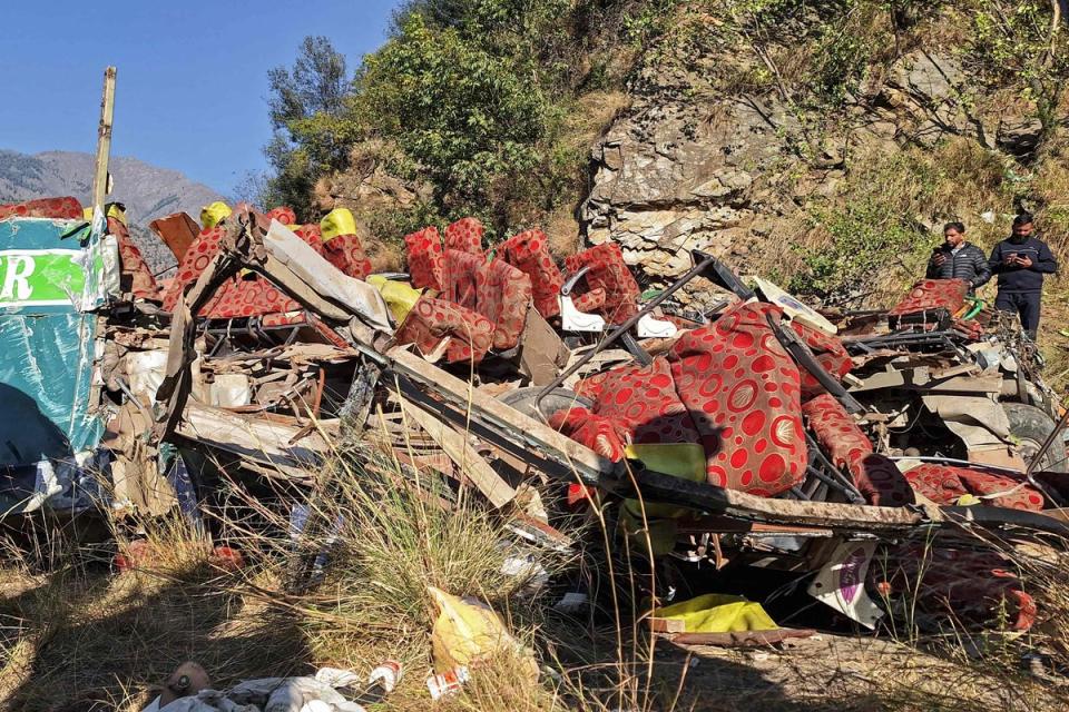 Men gather near the wrecked bus, subject to an accident on a remote mountain road in the Doda area, about 200km (124 miles) southeast of the Srinagar on 15 November 2023 (AFP via Getty Images)