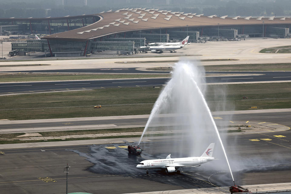 In this photo released by Xinhua News Agency, a C919 plane, China's first domestically made passenger jet is welcomed with water jets after completing its maiden commercial flight operated by China Eastern Airlines at the Beijing Capital International Airport in Beijing on Sunday, May 28, 2023. China's first domestically made passenger jet flew its maiden commercial flight on Sunday, as China looks to compete with industry giants such as Boeing and Airbus in the global aircraft market.(Wei Meng/Xinhua via AP)