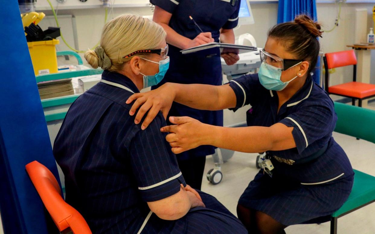 Vaccinations are set to begin tomorrow. Here, Matron May Parsons (R) talks to Heather Price (L) during training in the Covid-19 Vaccination Clinic at the University Hospital in Coventry - AFP