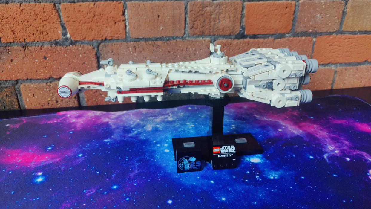  Lego Tantive IV set on a starry background, in front of a brick wall. 