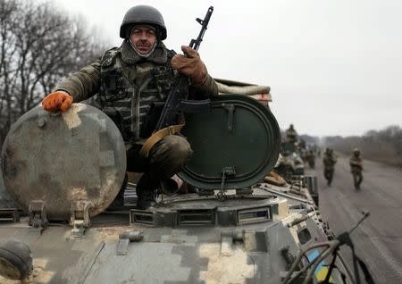 Members of the Ukrainian armed forces and armoured personnel carriers are seen preparing to move as they pull back from Debaltseve region, near Artemivsk February 26, 2015. REUTERS/Gleb Garanich