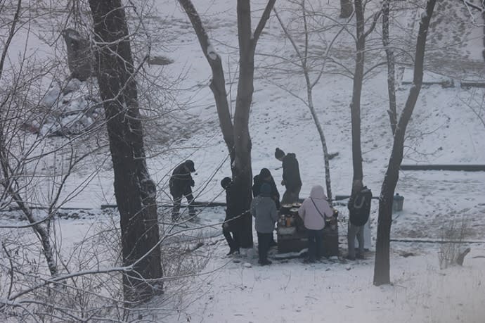 Mariupol residents cooking outdoors over open fires