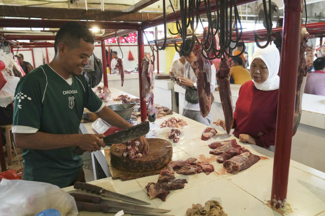 A butcher serves a customer at a market in Jakarta, Indonesia, Wednesday, March 22, 2023. Millions of Muslims in Indonesia are preparing to welcome the holy month of Ramadan, which is expected to start on Thursday, with traditions and ceremonies in the world's largest Muslim-majority country amid soaring food prices. (AP Photo/ Ahmad Ibrahim)