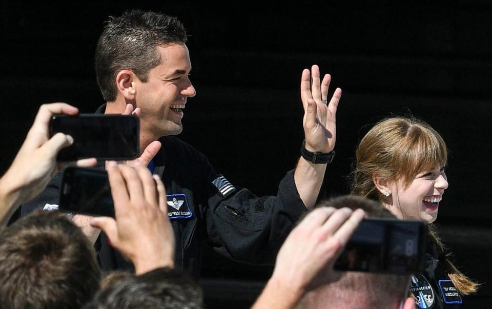 Inspiration4 astronauts Jared Isaacman and Hayley Arceneaux wave to the crowd in September 2021 as they head to pad 39A at NASA's Kennedy Space Center.