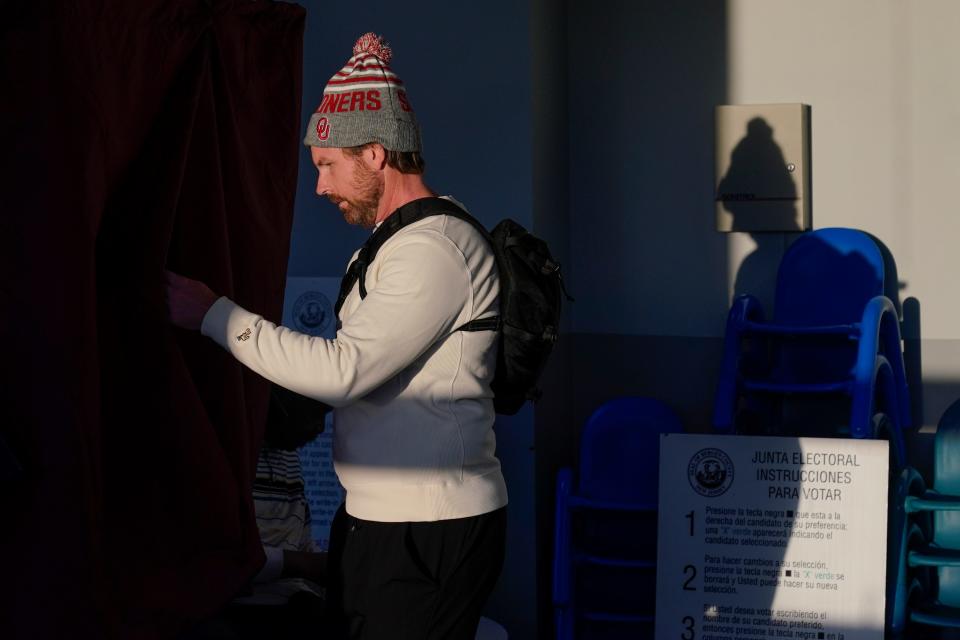 Cullen Bray enters a voting booth at a polling place in Edgewater, New Jersey, on Tuesday, Nov. 8, 2022.