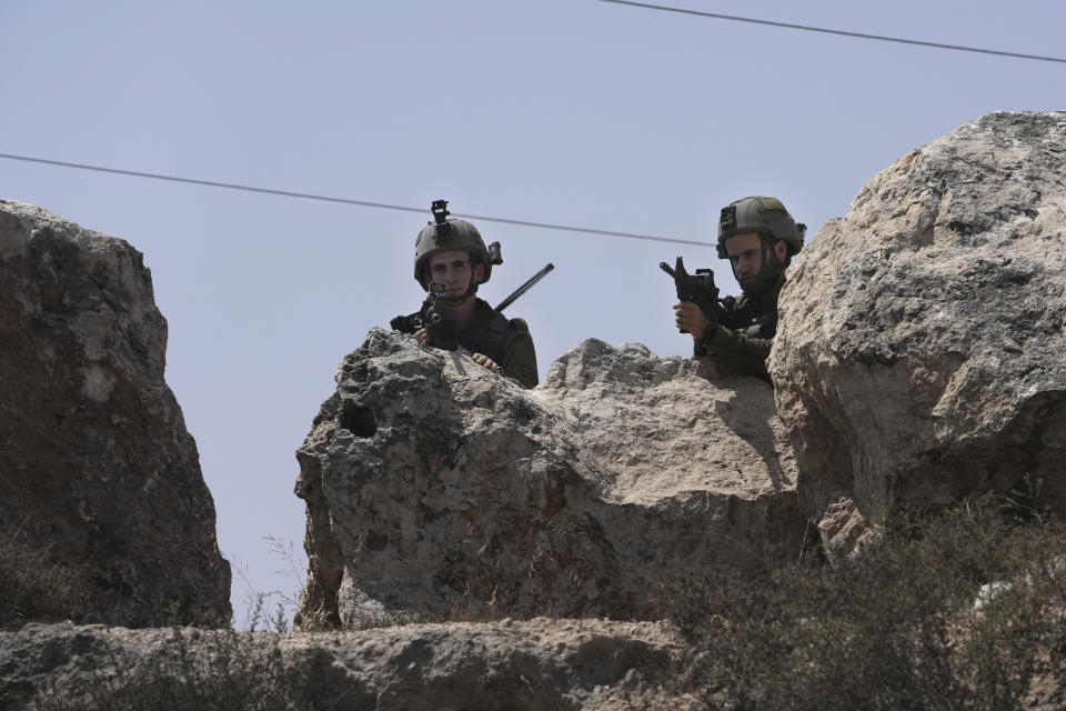 Israeli forces work at the site of a shooting attack near the West Bank city of Hebron, Monday, Aug. 21, 2023. Israeli authorities say that a suspected Palestinian attacker has killed an Israeli woman and seriously wounded a man in the incident. (AP Photo/Mahmoud Illean)