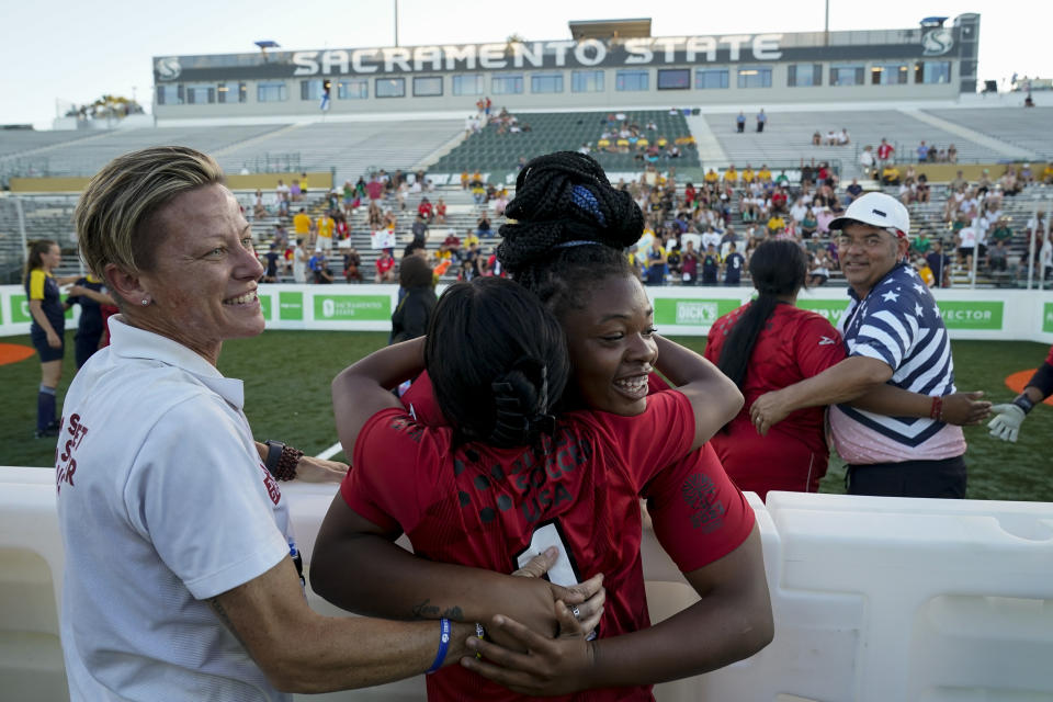 U.S. women's coach Lisa Wrightsman, left, celebrates with Sienna Jackson, center right, and Elizabeth Kin after the team's win over Sweden at the Homeless World Cup, Tuesday, July 11, 2023, in Sacramento, Calif. Wrightsman was a former college soccer player whose life was derailed by drug addiction when she heard about a soccer tournament for players from around the globe who have experienced homelessness. Wrightsman is now the coach for the U.S. women's team. The tournament made its U.S. debut July 8, and runs through Sunday. (AP Photo/Godofredo A. Vásquez)