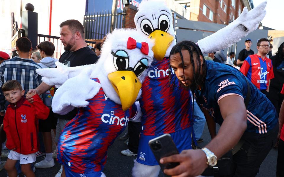 Crystal Palace mascots with a fan outside the stadium before the match - REUTERS