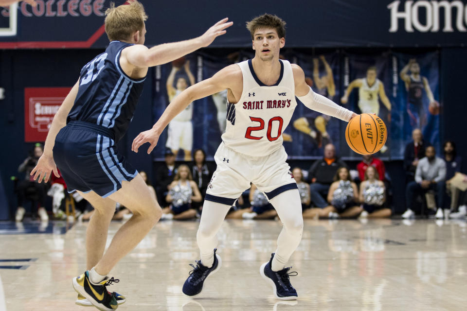 Saint Mary's guard Aidan Mahaney (20) dribbles the ball in front of San Diego guard Dominic Muncey during the first half of an NCAA college basketball game in Moraga, Calif., Saturday, Feb. 24, 2024. (AP Photo/John Hefti)