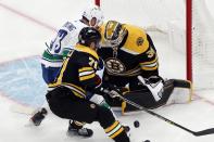 Vancouver Canucks' Justin Dowling (73) tries to get a shot off against Boston Bruins' Linus Ullmark (35) as Taylor Hall (71) defends during the second period of an NHL hockey game, Sunday, Nov. 28, 2021, in Boston. (AP Photo/Michael Dwyer)