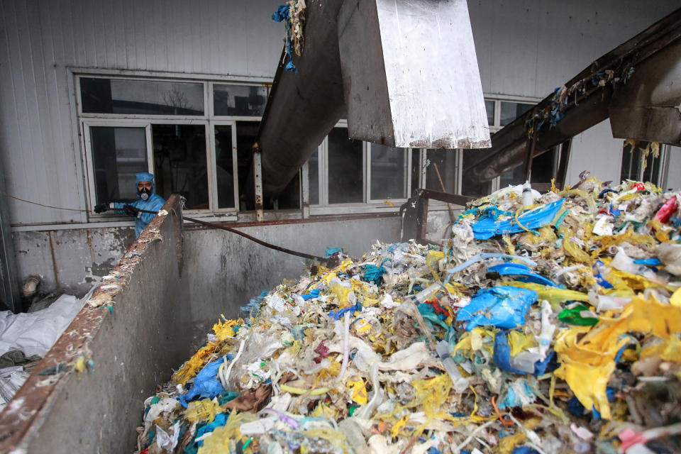 Un trabajador con ropa protectora tira desechos médicos en una planta de tratamiento especializada luego del brote de coronavirus en la ciudad de Wuhan, en Hubei. Foto: Getty Images