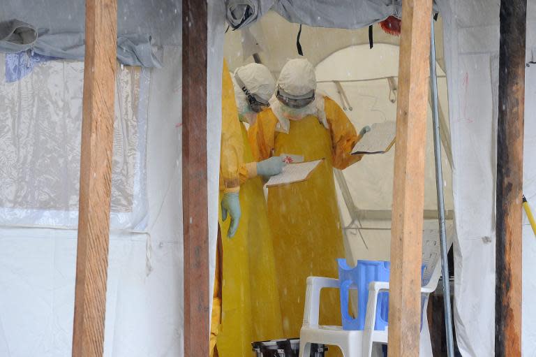 Health care workers, wearing protective suits, work at the Elwa hospital in Monrovia on August 30, 2014