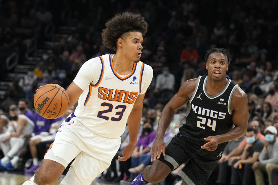 Phoenix Suns forward Cameron Johnson (23) drives on Sacramento Kings guard Buddy Hield during the second half of an NBA basketball game, Wednesday, Oct. 27, 2021, in Phoenix. Sacramento won 110-107. (AP Photo/Rick Scuteri)