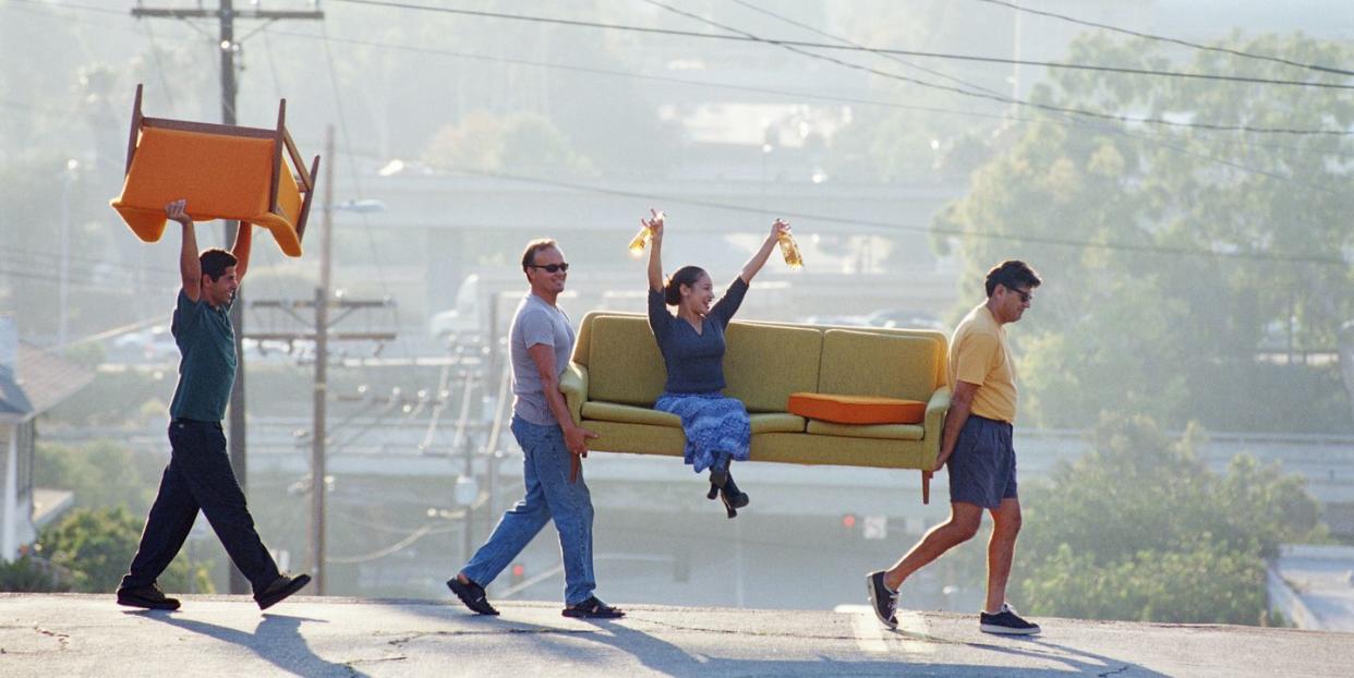 hispanicamer friends moving sofa,woman on sofa with beer