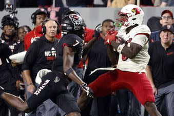 Louisville's Chris Bell catches the ball in front of North Carolina State's Shyheim Battle (7) during the second half of an NCAA college football game in Raleigh, N.C., Friday, Sept. 29, 2023. (AP Photo/Karl B DeBlaker)
