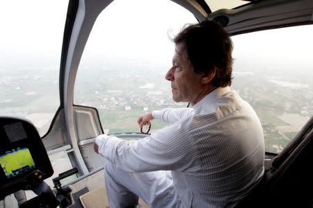 Imran Khan, chairman of the Pakistan Tehreek-e-Insaf (PTI), political party, holds his tasbih, or prayer beads, as he sits in a helicopter on his way to a campaign rally ahead of general elections in Narowal, Pakistan July 12, 2018. Picture taken July 12, 2018. REUTERS/Stringer