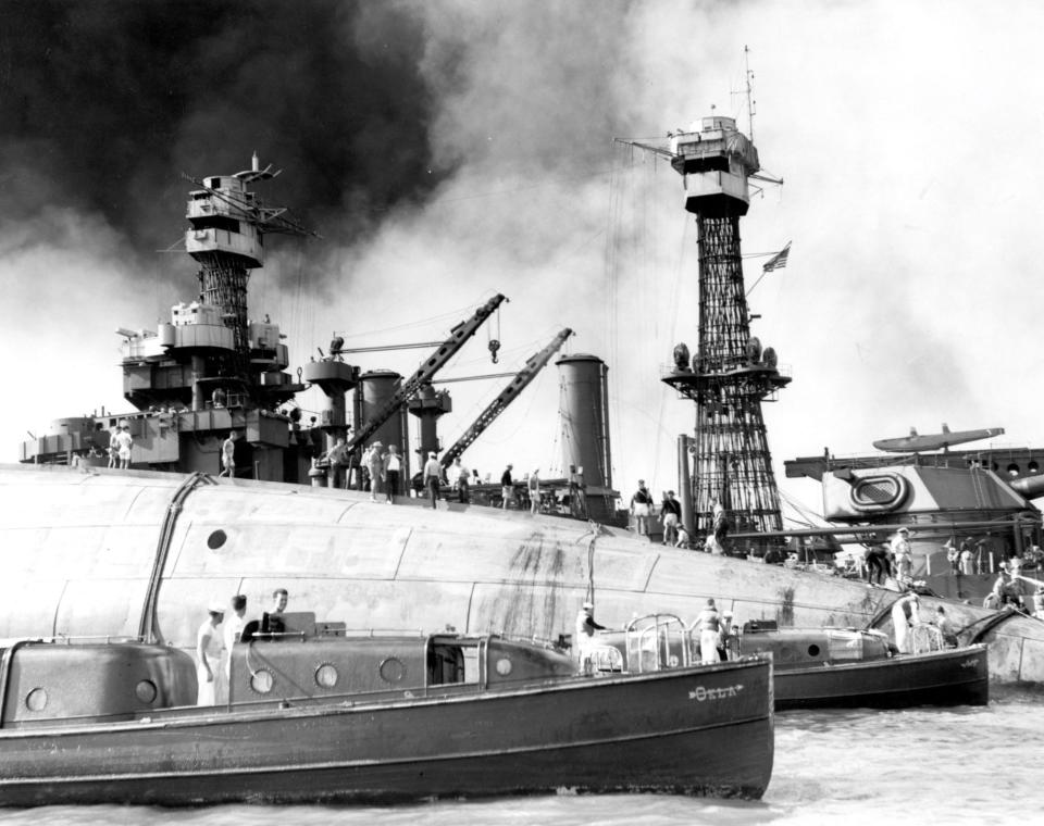 Rescue teams at work on the capsized hull of USS Oklahoma (BB-37), seeking crew members trapped inside, 7 December 1941. The starboard bilge keel is visible at the top of the upturned hull. Officers' Motor Boats from Oklahoma and USS Argonne (AG-31) are in the foreground. USS Maryland (BB-46) is in the background. Official U.S. Navy Photograph, now in the collections of the National Archives.