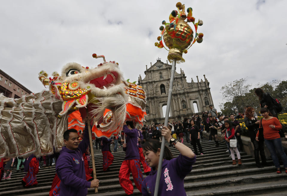 In this Feb. 1, 2014 photo, local artists perform dragon at the famous tourist spot the Ruins of St. Paul's during a Chinese New Year celebration in Macau. This year marks the year of the horse in the Chinese calendar. The annual holiday is the busiest time of year for the former Portuguese colony, which became a special Chinese region in 1999. Many of the millions of mainland Chinese on the move during the holiday, often referred to as the world’s biggest migration, head to Macau during the festival. (AP Photo/Vincent Yu)