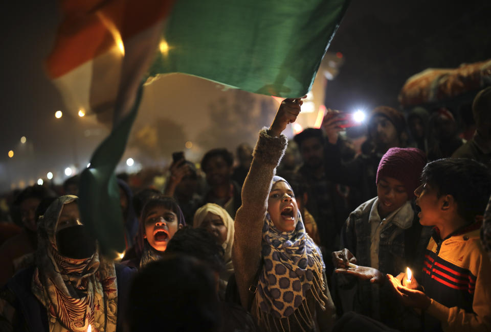 In this Tuesday, Jan. 21, 2020 photo, a young girl waves the Indian national flag as she shouts slogans at a protest site at Shaheen Bagh, in New Delhi, India. Muslim women are transcending the confines of their homes to lay claim to the streets of this nondescript Muslim neighborhood in the Indian capital and slowly transforming it into a nerve center of resistance against a new citizenship law that has unleashed protests across the country. The neighborhood rings with chants of “Inquilab Zindabad", a phrase which translates to “Long live the revolution!” (AP Photo/Altaf Qadri)