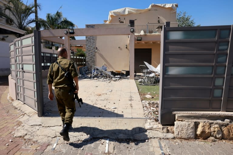 An Israeli soldier checks a house that was hit by a Hezbollah rocket in Kiryat Shmona, northern Israel, near the Lebanon border (Menahem Kahana)