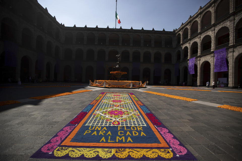 A patio inside the presidential palace is decorated with the traditional colors of Day of The Dead, with the Spanish message "A flower for each soul," in Mexico City, Saturday, Oct. 31, 2020. The holiday isn't the same in a year so marked by death in a country where more than 90,000 people have died of COVID-19, many cremated rather than buried and with cemeteries forced to close. (AP Photo/Fernando Llano)