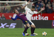 Sevilla's Banega, right, fight for the ball with FC Barcelona's Arthur Melo, during a Spanish Copa del Rey soccer match between Sevilla and FC Barcelona at the Ramon Sanche Pizjuan stadium in Seville, Spain, Wednesday Jan. 23, 2019. (AP Photo/Miguel Morenatti)