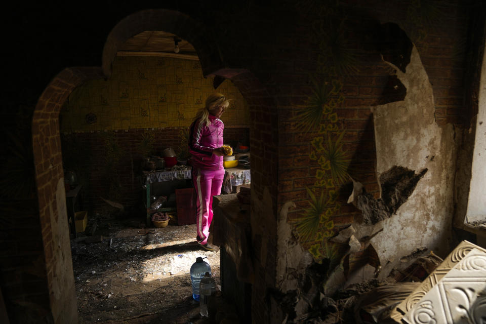 Iryna Martsyniuk, 50, collects belongings from her house, heavily damaged after a Russian bombing in Velyka Kostromka village, Ukraine, Thursday, May 19, 2022. Martsyniuk and her three young children were at home when the attack occurred in the village, a few kilometres from the front lines, but they all survived unharmed. (AP Photo/Francisco Seco)