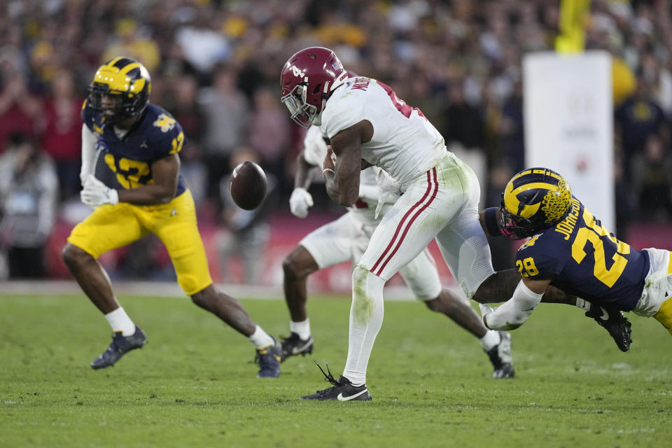 Alabama quarterback Jalen Milroe (4) fumbles as he is tackled by Michigan defensive back Quinten Johnson (28) during the second half in the Rose Bowl CFP NCAA semifinal college football game Monday, Jan. 1, 2024, in Pasadena, Calif. Michigan recovered the ball on the play. (AP Photo/Mark J. Terrill)