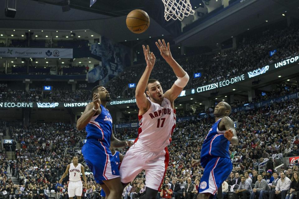 Toronto Raptors' Jonas Valanciunas, center, looses control of the ball after being fouled by Los Angeles Clippers DeAndre Jordan, left, as Clippers' Jamal Crawford looks on during the first half of an NBA basketball game, Saturday, Jan. 25, 2014 in Toronto. (AP Photo/The Canadian Press, Chris Young)