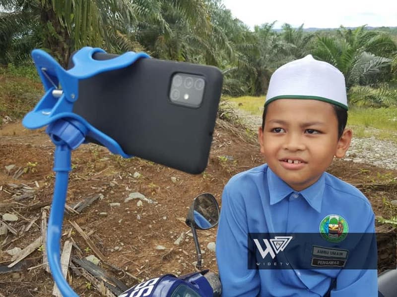 The boy who is from Kampung Sinar Baru, Batu 12 didn’t want to miss out on meeting his teachers and friends in the Google Meet session. — Picture from Facebook/Wide TV