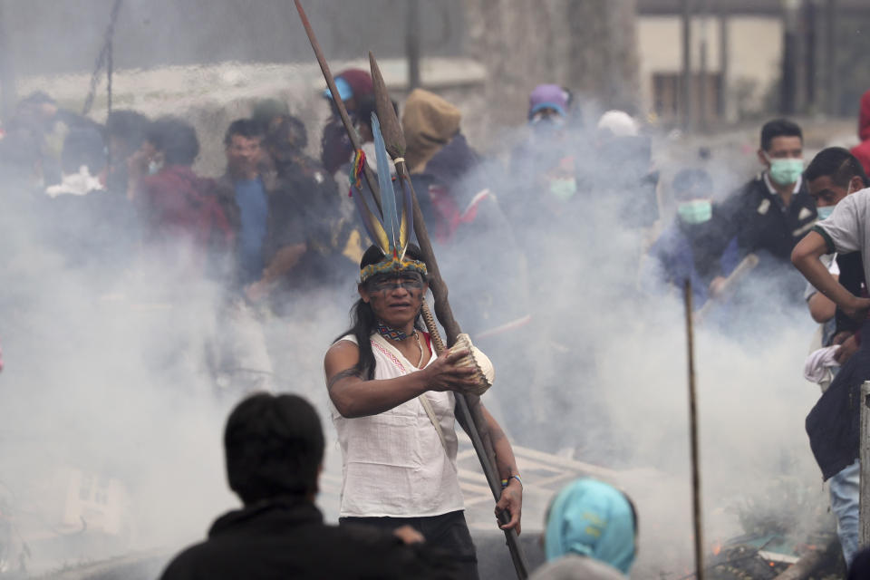 Anti-government demonstrator stands in the middle of tear gas during clashes with police in Quito, Ecuador, Friday, Oct. 11, 2019. Protests, which began when President Lenin Moreno's decision to cut subsidies led to a sharp increase in fuel prices, have persisted for days. (AP Photo/Dolores Ochoa)