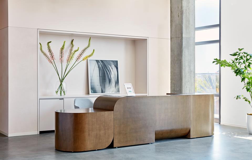 Rapt Studio’s custom reception desk echoes the rounded forms of the Goop logo.