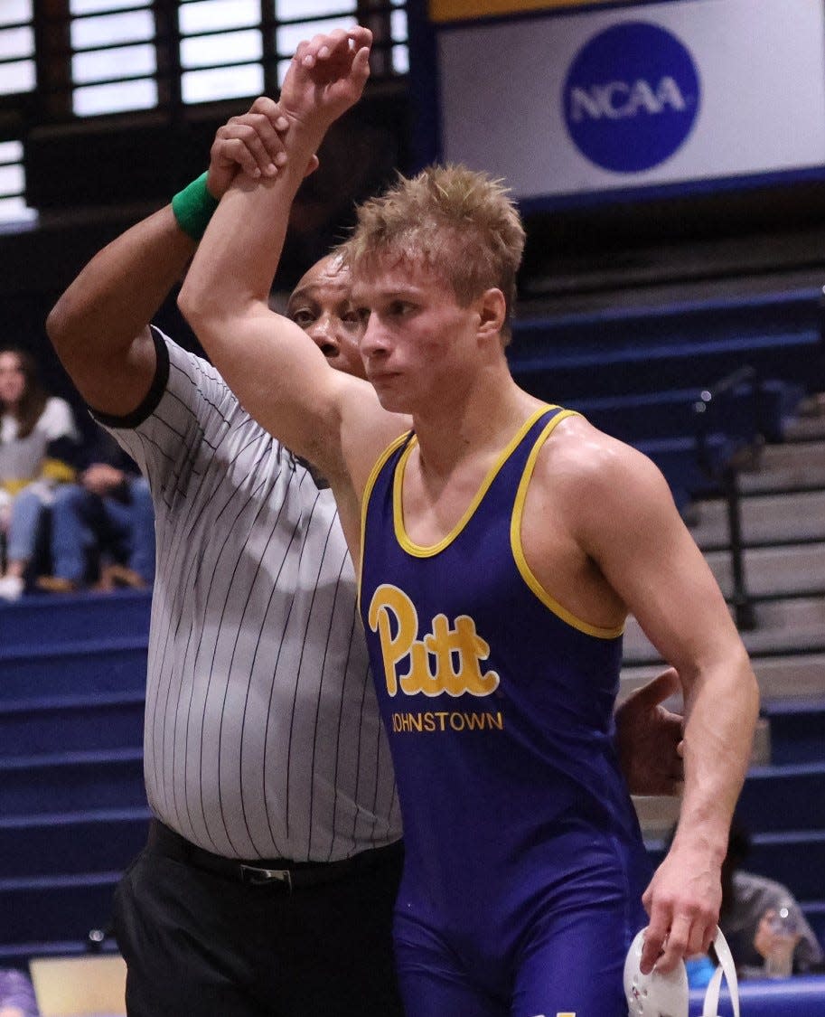 Pitt-Johnstown's Jacob Ealy, a former state champion at Hopewell, has his arm raised by an official following a win in a match this season.