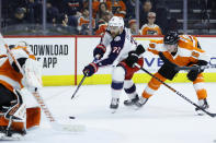 Columbus Blue Jackets' Nick Foligno (71) tries to get a shot past Philadelphia Flyers' Carter Hart, left, as Travis Sanheim (6) defends during the third period of an NHL hockey game, Tuesday, Feb. 18, 2020, in Philadelphia. (AP Photo/Matt Slocum)