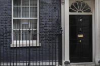 A drawing of a rainbow with the words "we are in this together" is displayed in one of the windows of 10 Downing Street in London, Thursday, April 9, 2020. British Prime Minister Boris Johnson remains in intensive care with the coronavirus but is improving and sitting up in bed, a senior government minister said Wednesday, as the U.K. recorded its biggest spike in COVID-19 deaths to date. The new coronavirus causes mild or moderate symptoms for most people, but for some, especially older adults and people with existing health problems, it can cause more severe illness or death. (AP Photo/Kirsty Wigglesworth)