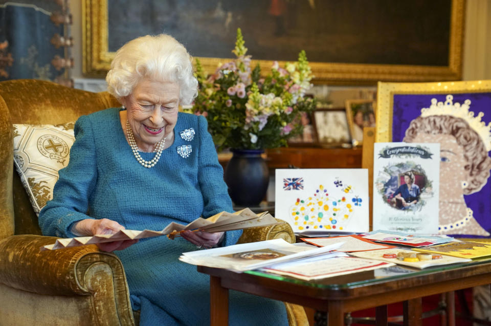 WINDSOR, ENGLAND - FEBRUARY 04: Queen Elizabeth II looks at a fan as she views a display of memorabilia from her Golden and Platinum Jubilees in the Oak Room at Windsor Castle on February 4, 2022 in Windsor, England. The fan was presented to Queen Victoria to mark her Golden Jubilee in 1887 by the then Prince and Princess of Wales, later Edward VII and Queen Alexandra. The Queen has since travelled to her Sandringham estate where she traditionally spends the anniversary of her accession to the throne - February 6 - a poignant day as it is the date her father King George VI died in 1952. (Photo by Steve Parsons-WPA Pool/Getty Images)