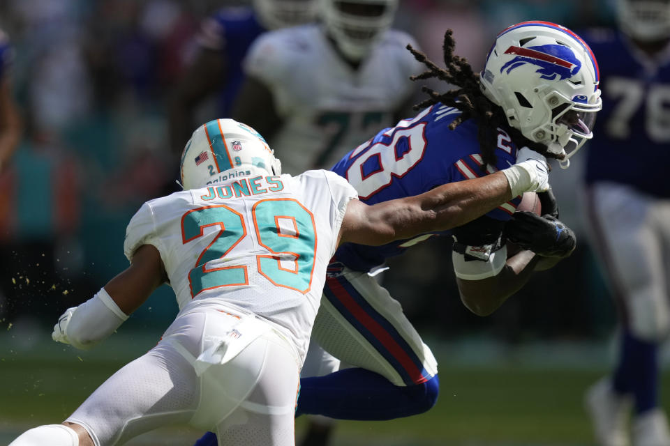 Miami Dolphins safety Brandon Jones (29) grabs Buffalo Bills running back James Cook (28) during the second half of an NFL football game, Sunday, Sept. 25, 2022, in Miami Gardens, Fla. (AP Photo/Rebecca Blackwell)