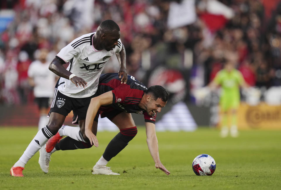 D.C. United forward Christian Benteke, left, and Toronto FC defender Matt Hedges battle for the ball during first-half MLS soccer match action in Toronto, Ontario, Saturday, May 27, 2023. (Chris Young/The Canadian Press via AP)