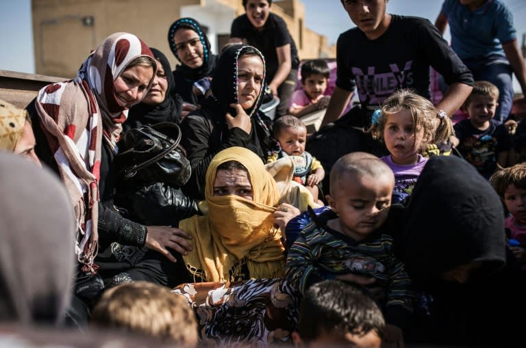 Refugees cross the Syria-Turkey border on June 22, 2015, as they return to the northern Syrian town of Tal Abyad after Kurdish forces re-took control of the border-town from Islamic State group militants