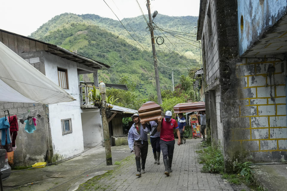 Residents carry coffins of those who died in landslides in El Placer, Ecuador, Monday, June 17, 2024. (AP Photo/Dolores Ochoa)
